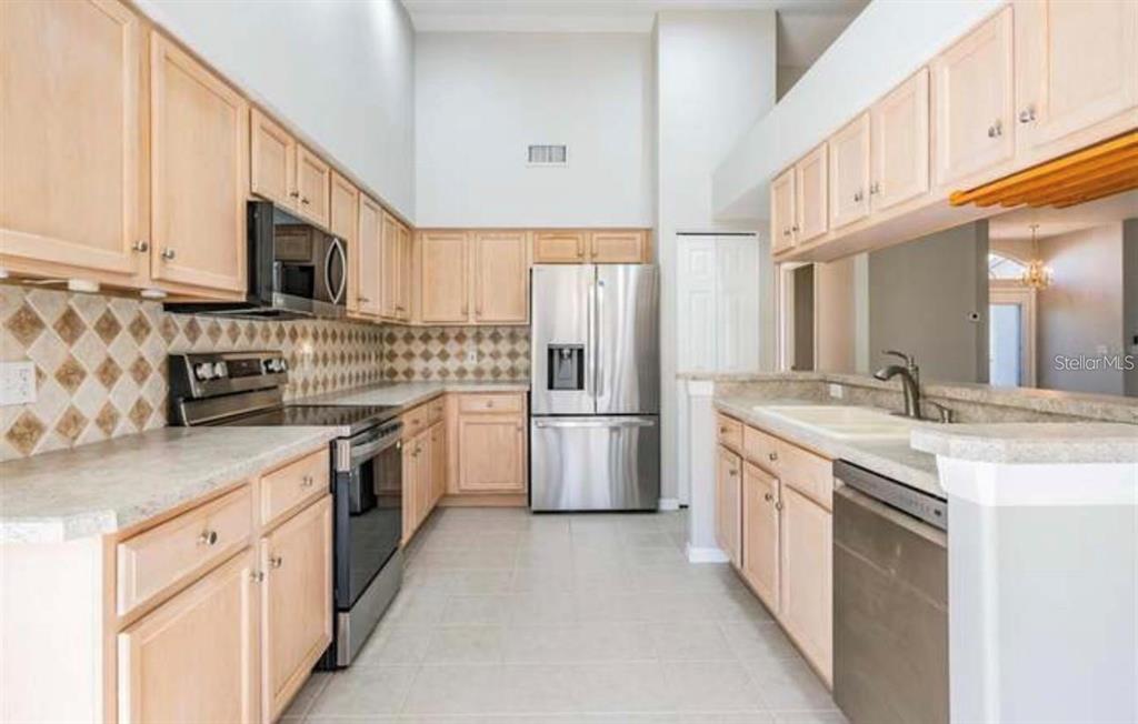 1520 Canberley Court Trinity, FL 34655 - Photo 9 of 35 a kitchen with stainless steel appliances granite countertop a stove a sink and a refrigerator