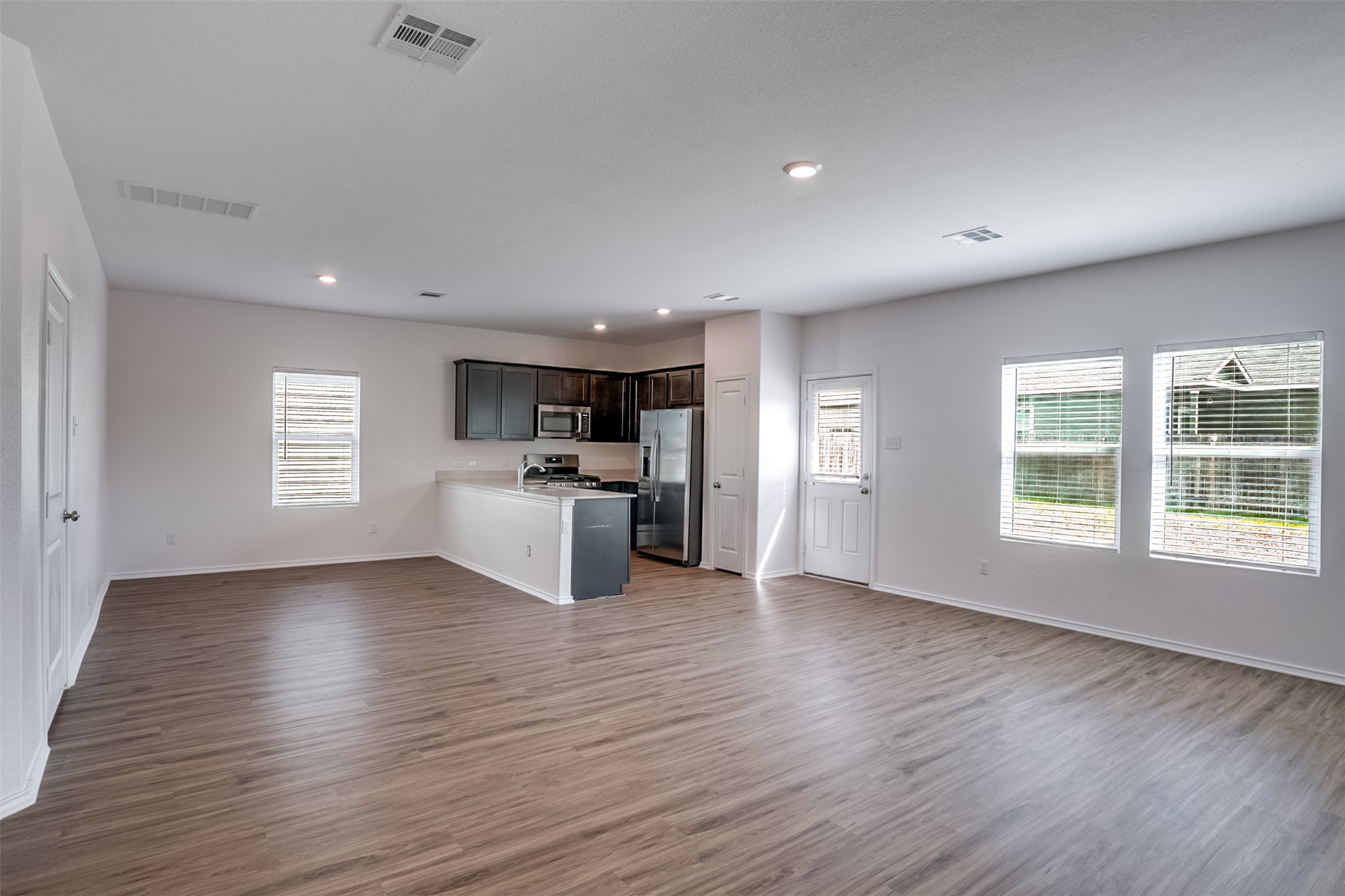 428 Gabbro Gardens Maxwell, TX 78656 - Photo 26 of 26 Kitchen with open floor plan, a peninsula, stainless steel appliances, light countertops, and dark wood-type flooring