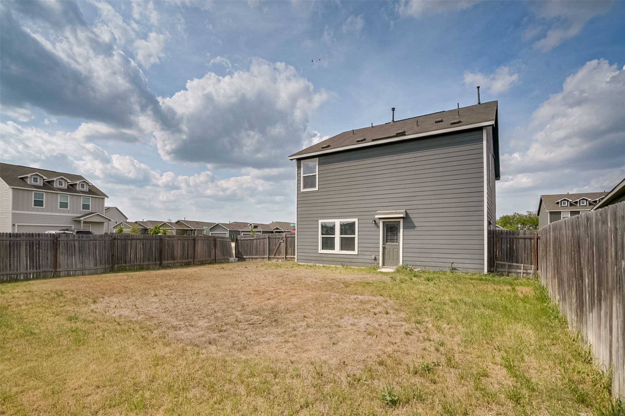 428 Gabbro Gardens Maxwell, TX 78656 - Photo 20 of 26 Back of property featuring a fenced backyard and a residential view