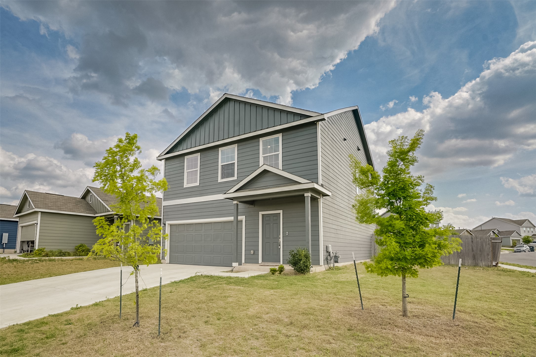 428 Gabbro Gardens Maxwell, TX 78656 - Photo 22 of 26 View of front of home with a garage, board and batten siding, driveway, and a front yard