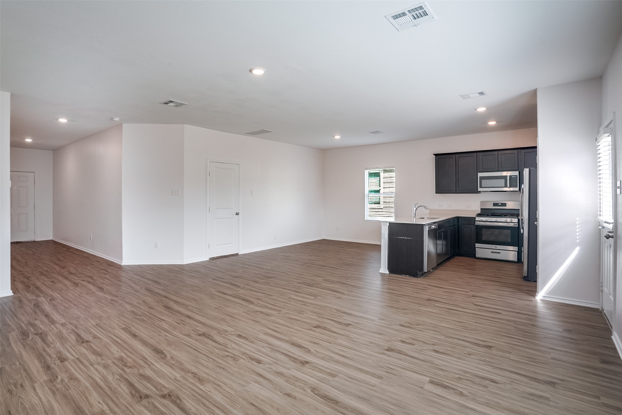 428 Gabbro Gardens Maxwell, TX 78656 - Photo 24 of 26 Kitchen featuring open floor plan, a peninsula, light countertops, stainless steel appliances, and recessed lighting