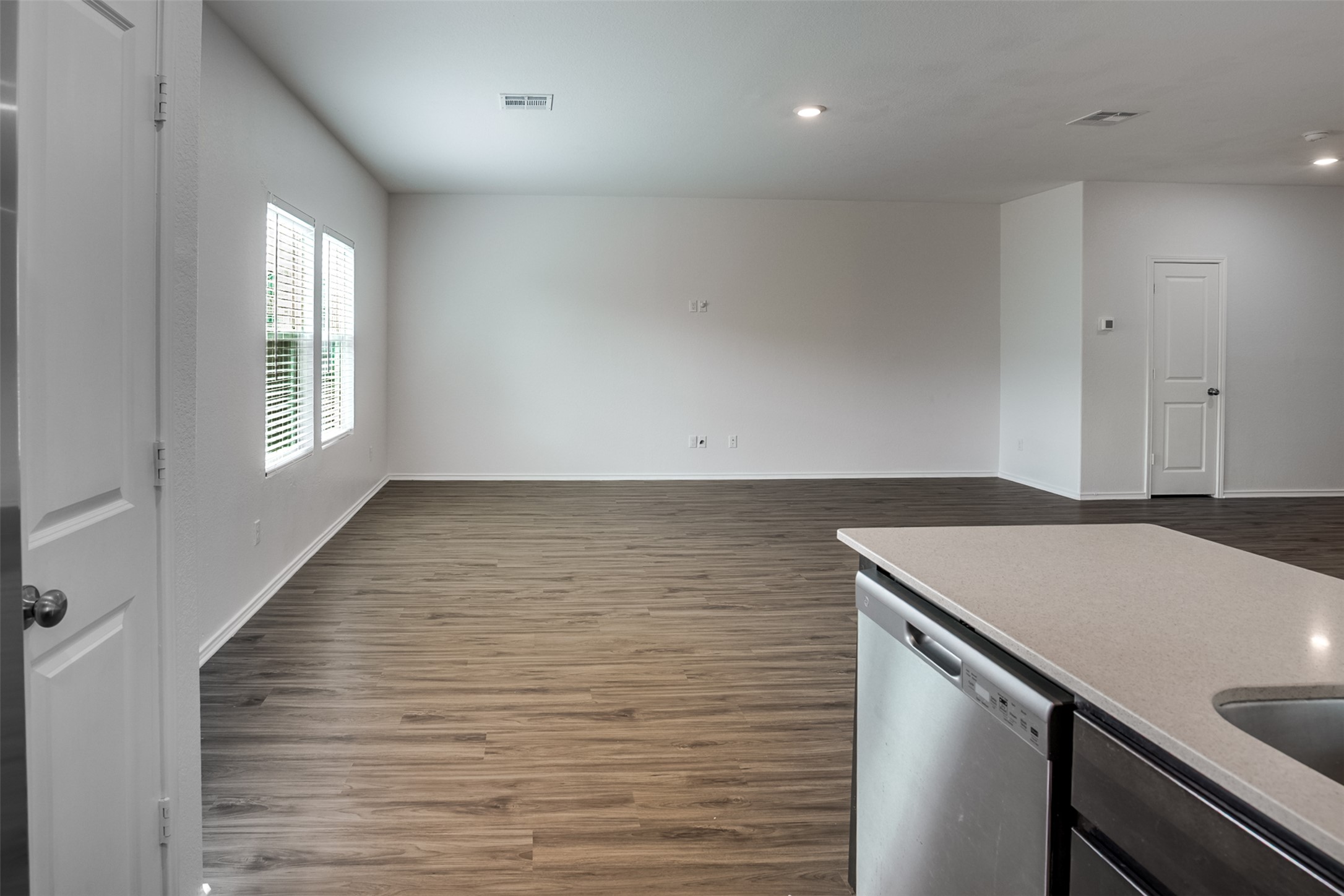 428 Gabbro Gardens Maxwell, TX 78656 - Photo 25 of 26 Kitchen with dishwasher, dark wood-type flooring, light stone countertops, open floor plan, and recessed lighting
