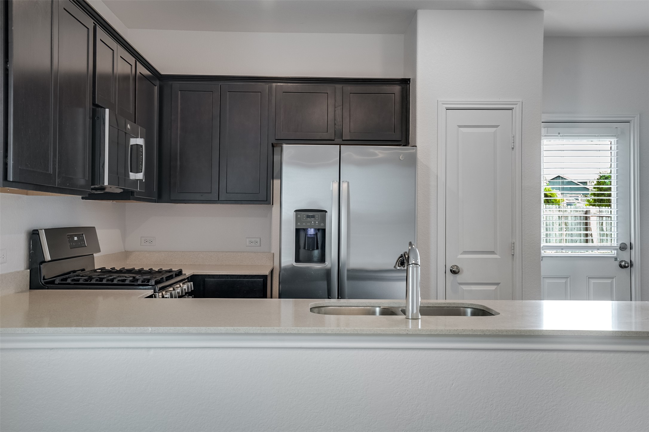 428 Gabbro Gardens Maxwell, TX 78656 - Photo 6 of 26 Kitchen featuring stainless steel appliances, a peninsula, and light stone counters