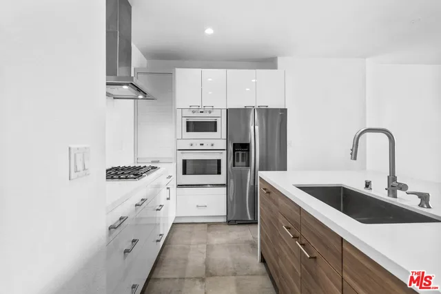 a kitchen with stainless steel appliances a sink stove and refrigerator