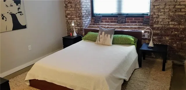 a bed sitting in a bedroom next to a lamp