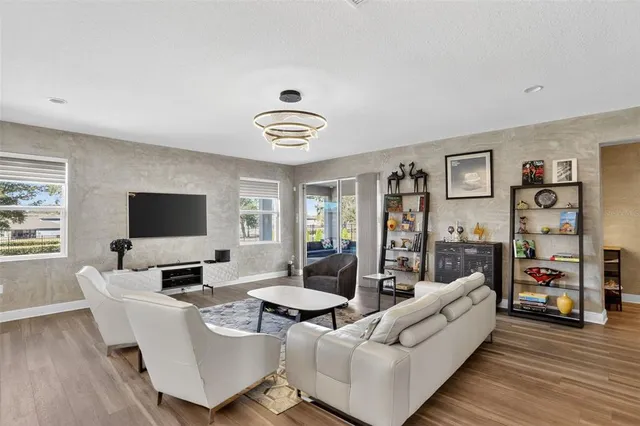 a living room with furniture kitchen view and a window