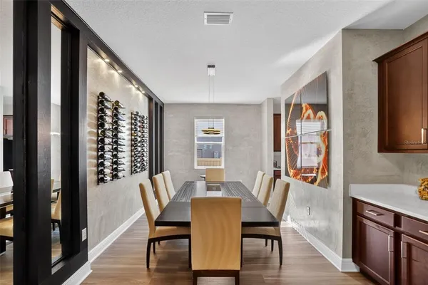 a kitchen with stainless steel appliances granite countertop a refrigerator a stove a sink a dining table and chairs