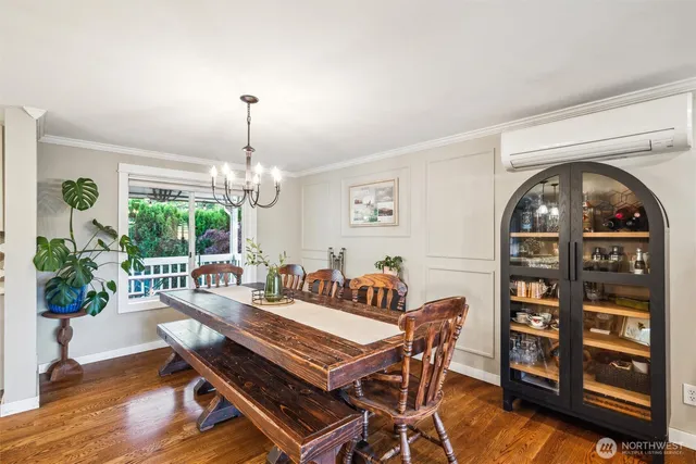 a dining room with furniture a chandelier and wooden floor