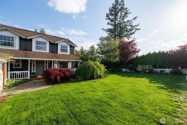 a view of a house with backyard and a tree