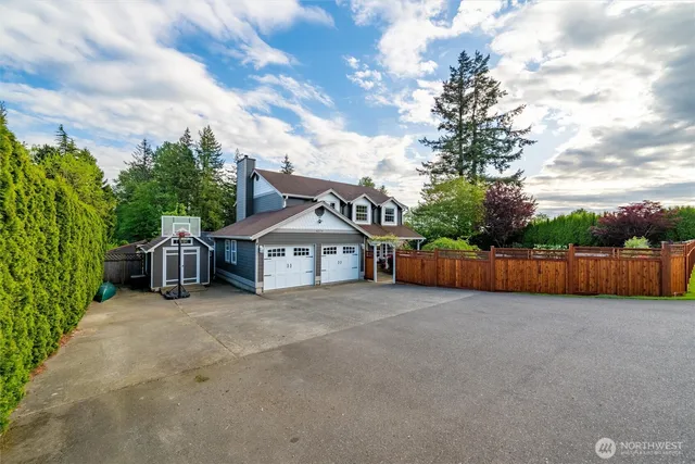 a view of a house with wooden fence next to a big yard