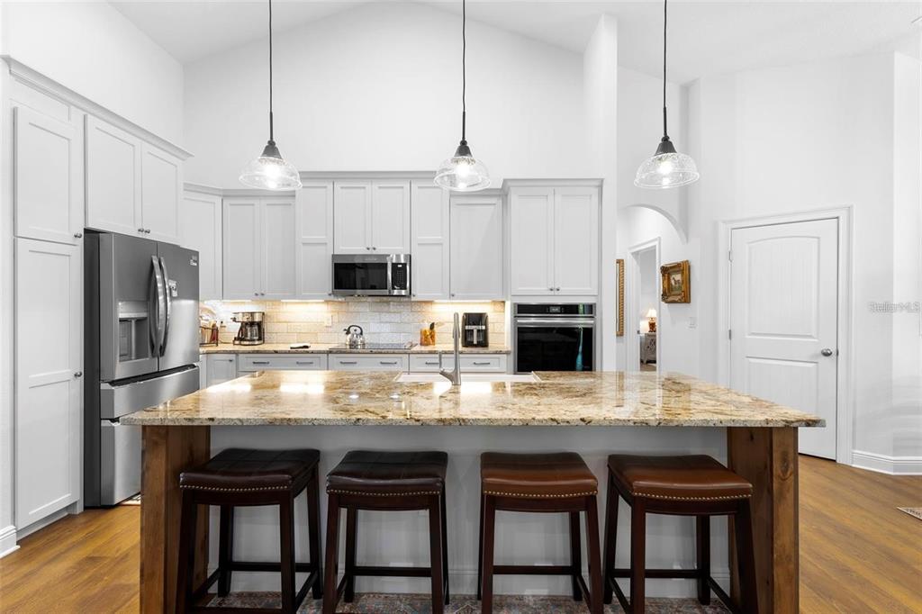 700 Old Geneva Road Geneva, FL 32732 - Photo 12 of 79 a kitchen with granite countertop a table chairs stainless steel appliances and cabinets