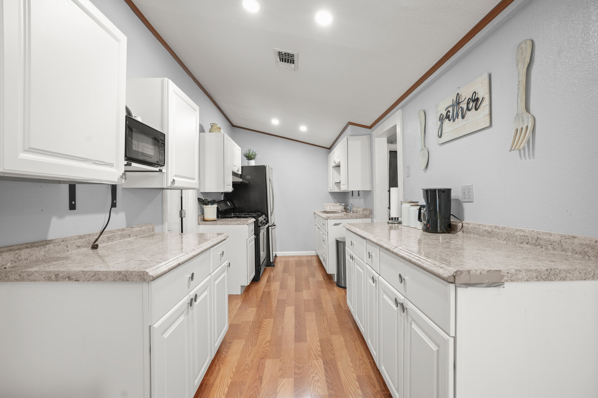 1908 Holly Street Austin, TX 78702 - Photo 10 of 22 Bright galley kitchen with white cabinetry and ample counter space.
