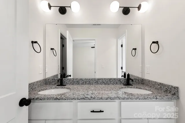 a bathroom with a granite countertop sink and a mirror