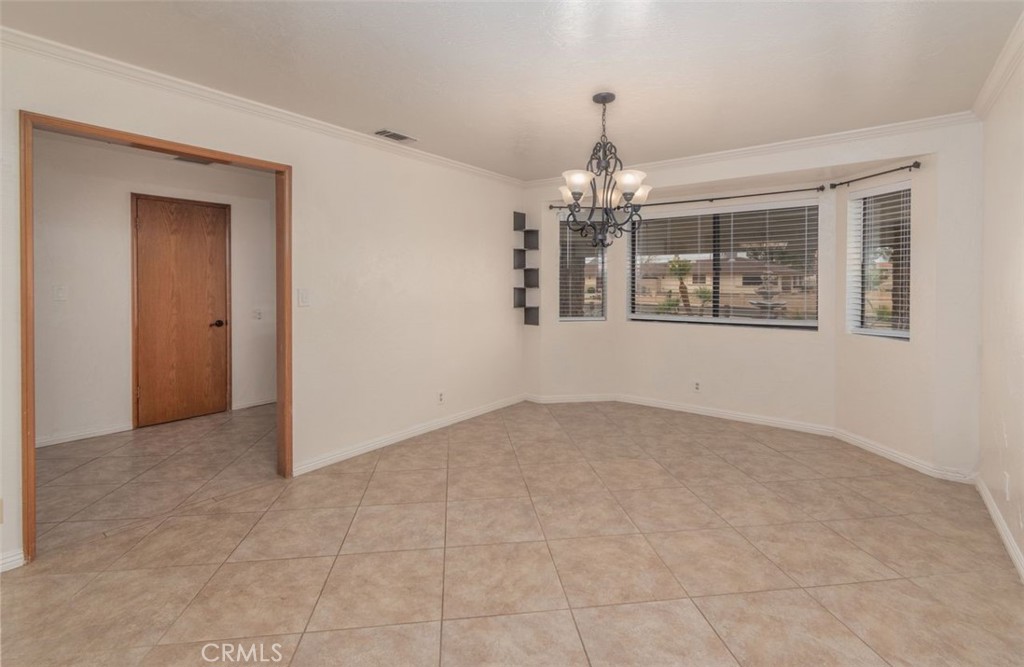 14760 Keota Road Apple Valley, CA 92307 - Photo 11 of 34 an empty room with chandelier and windows