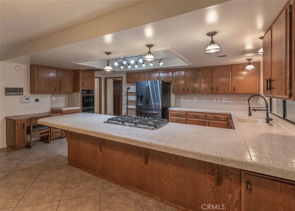 14760 Keota Road Apple Valley, CA 92307 - Photo 14 of 34 a large kitchen with a sink and chandelier