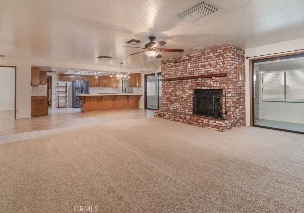 14760 Keota Road Apple Valley, CA 92307 - Photo 9 of 34 an empty room with a fireplace and fan