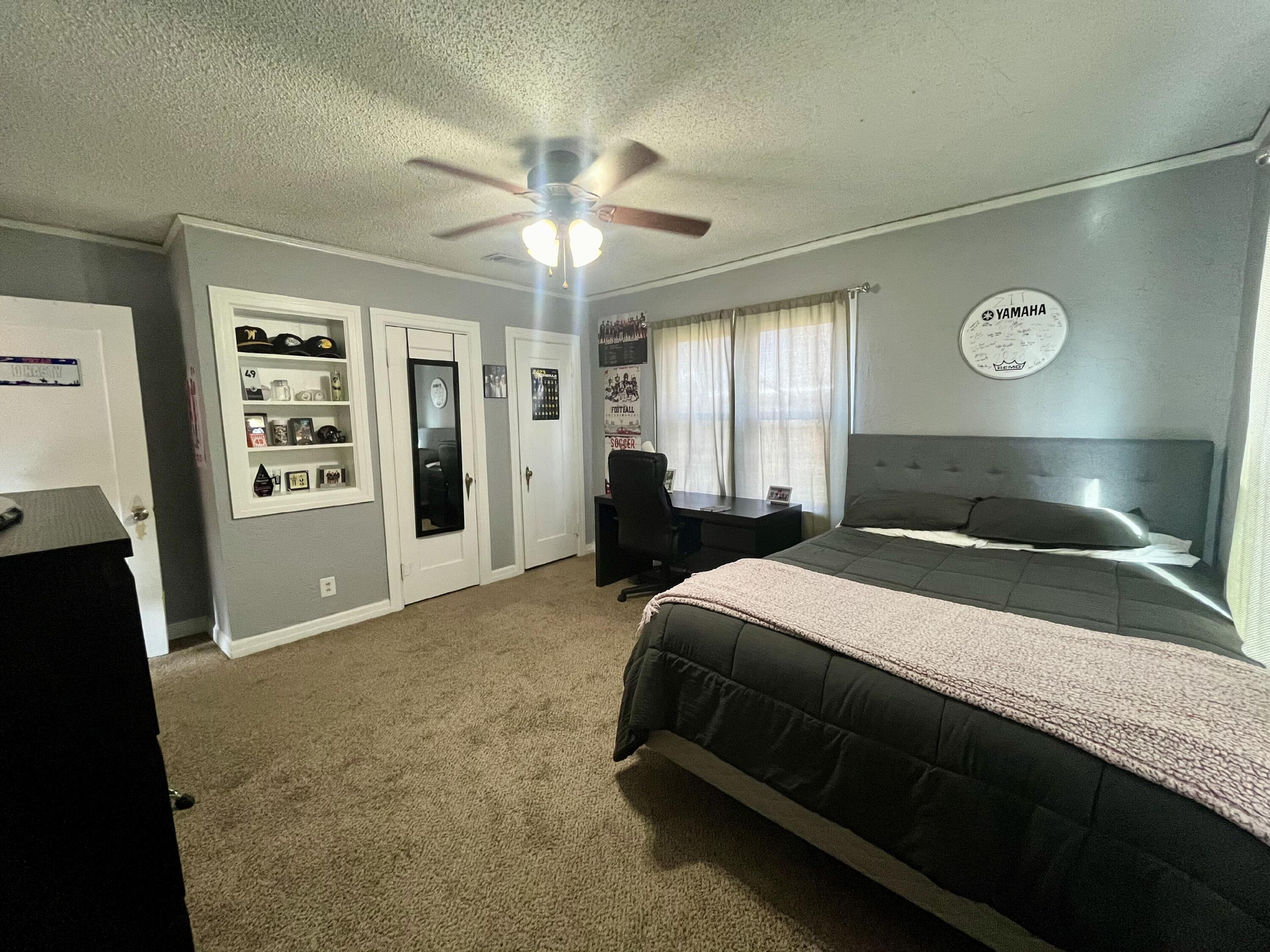1724 28th Street Lubbock, TX 79411 - Photo 14 of 26 a bedroom with a bed and a chandelier