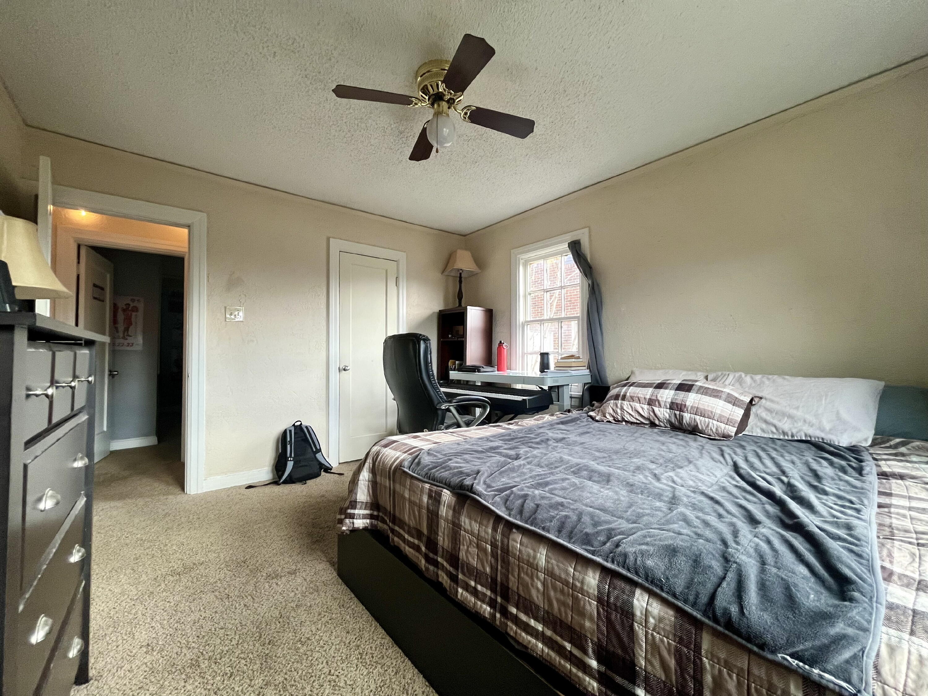 1724 28th Street Lubbock, TX 79411 - Photo 18 of 25 a bedroom with a bed a couch and a ceiling fan