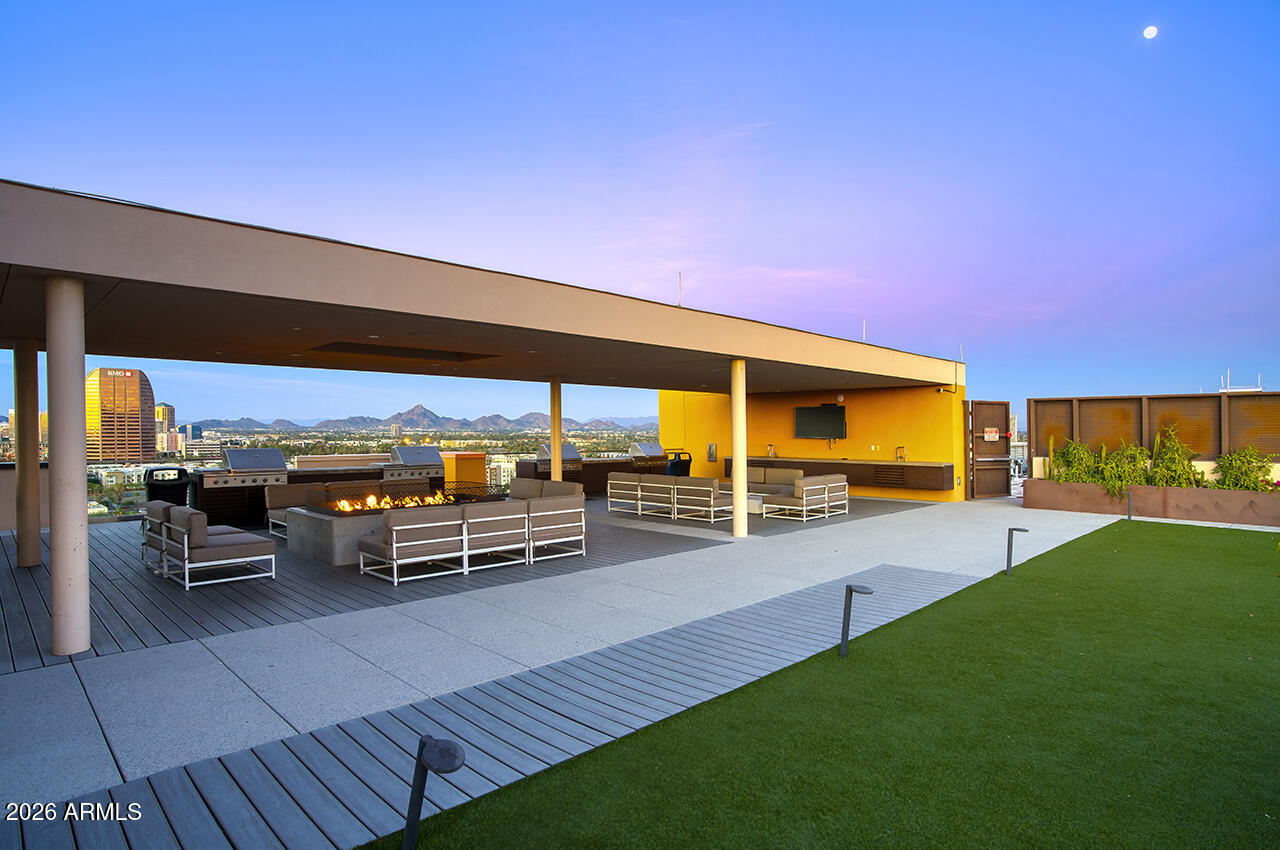 200 West Portland Street, Unit 1113 Phoenix, AZ 85003 - Photo 33 of 85 a view of a patio with table and chairs under an umbrella next to a yard