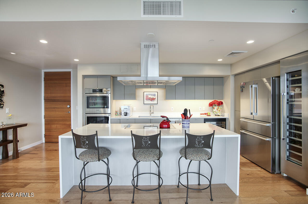 200 West Portland Street, Unit 1113 Phoenix, AZ 85003 - Photo 5 of 85 a kitchen with stainless steel appliances a dining table chairs refrigerator and sink