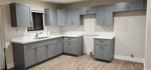 a kitchen with a sink cabinets and wooden floor