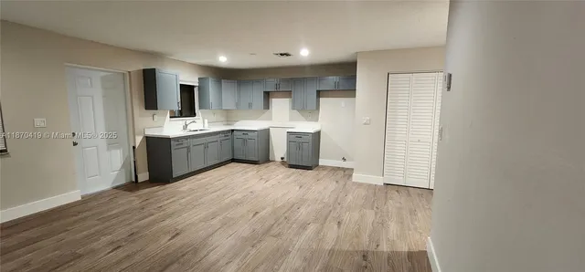 a view of a kitchen with wooden floor and electronic appliances