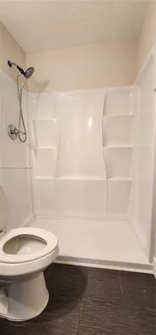 a bathroom with a toilet and a shower