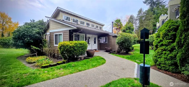 a front view of a house with a yard and potted plants