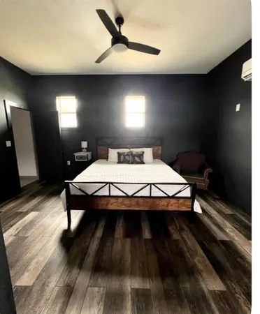 a bedroom with a bed and wooden floor