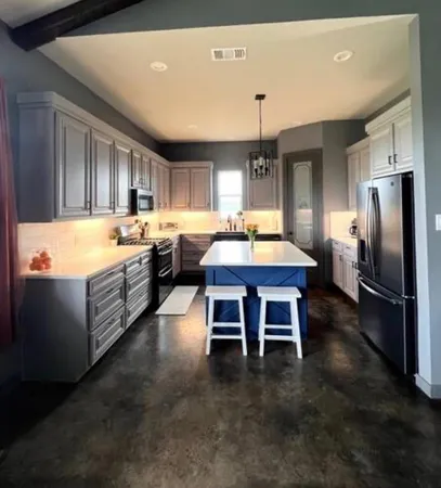 a large kitchen with kitchen island a large island in it