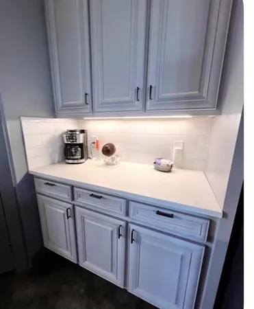 a kitchen with white cabinets and sink