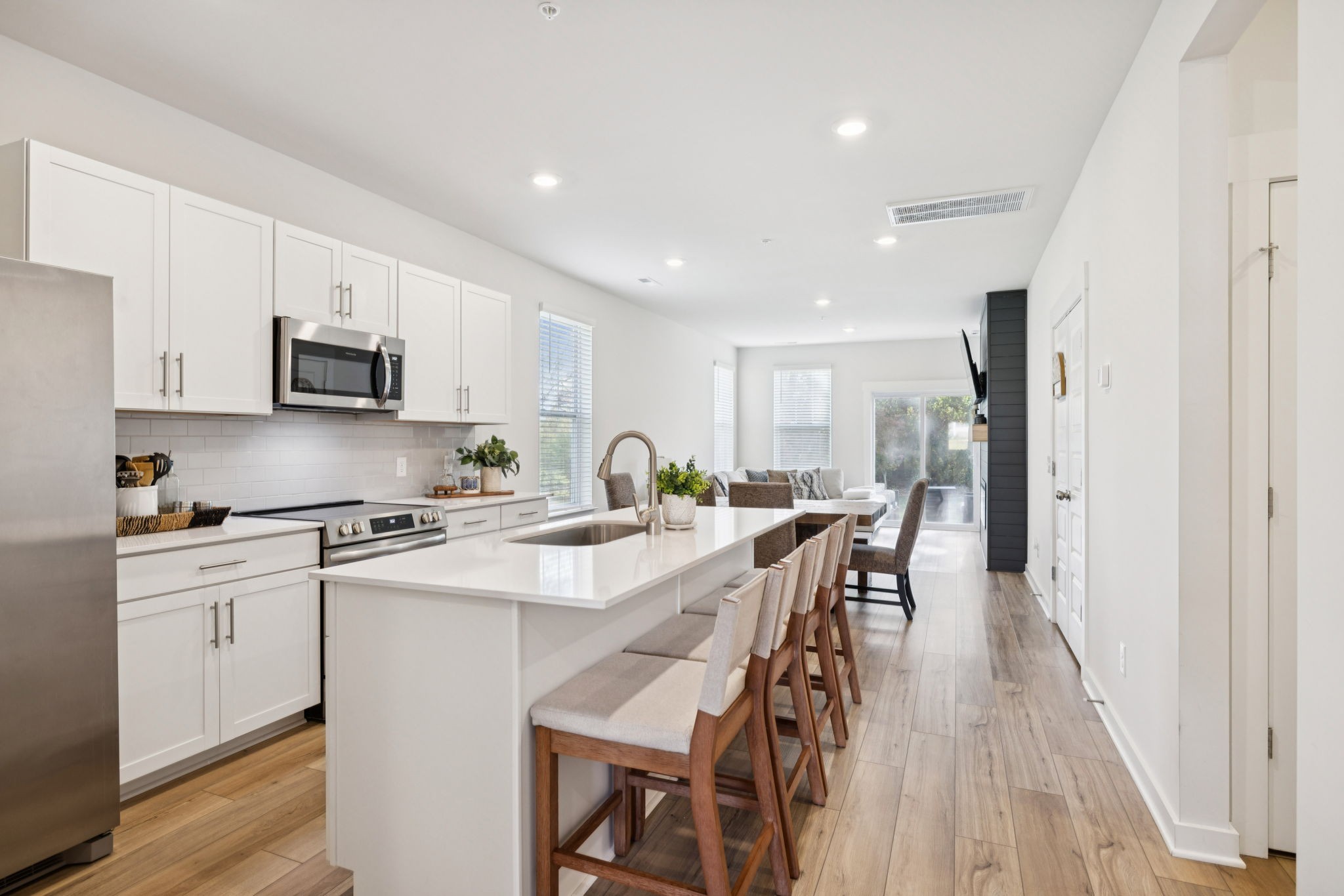 647 Birdie Drive Spring Hill, TN 37174 - Photo 2 of 15 a kitchen with stainless steel appliances granite countertop a stove a sink a microwave a refrigerator a stove and white cabinets with wooden floor