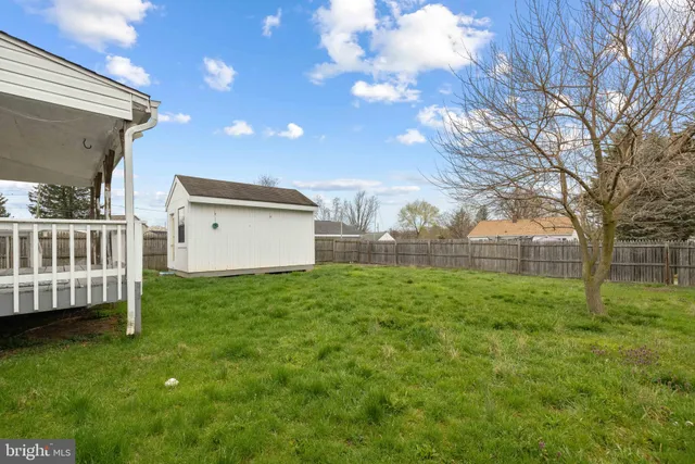 a view of backyard with barbeque grill and wooden fence