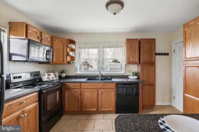 a kitchen with stainless steel appliances granite countertop a stove a sink dishwasher and a refrigerator