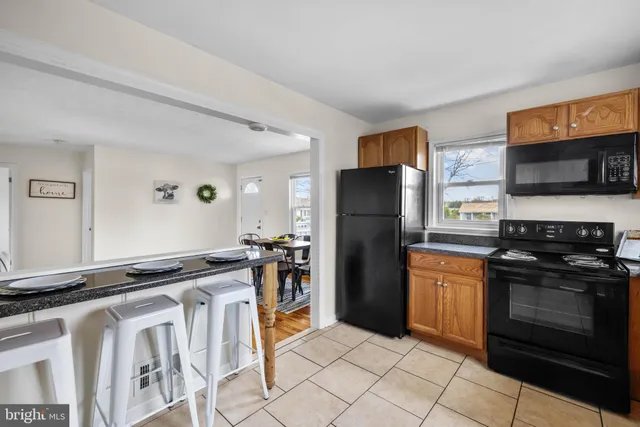 a kitchen with granite countertop a refrigerator stove and microwave