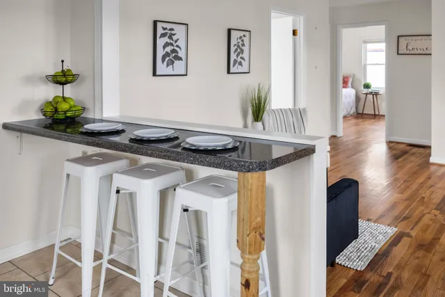 a view of a kitchen area with furniture and wooden floor