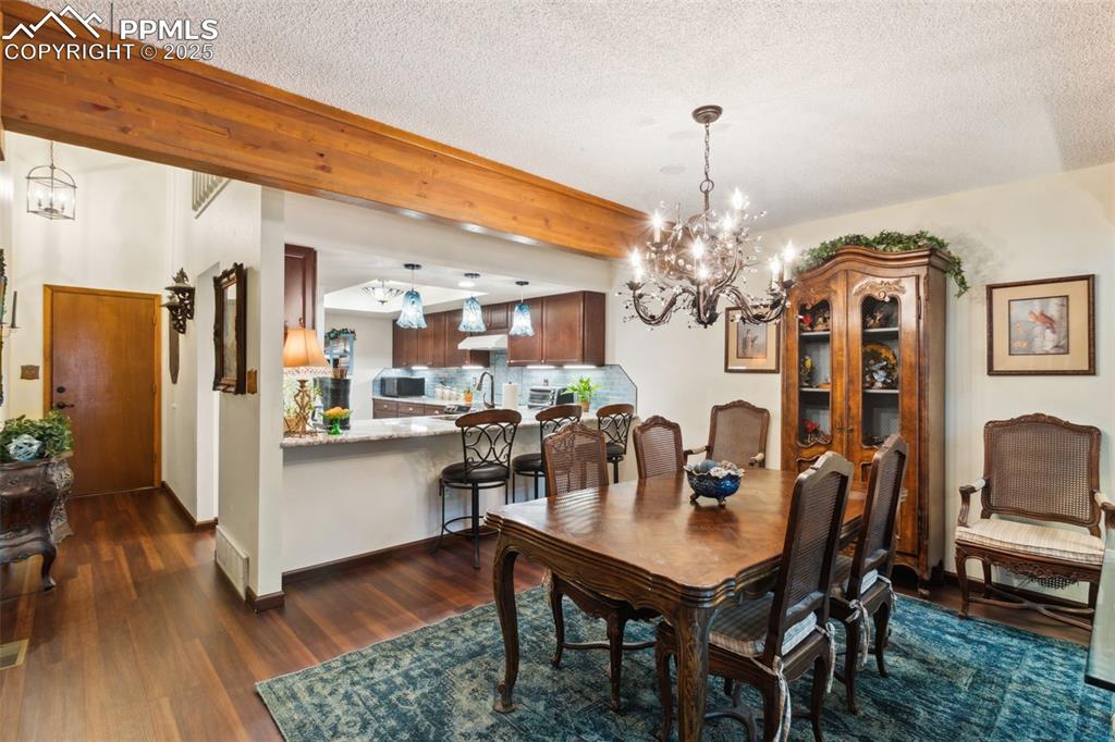 4835 Castledown Road Colorado Springs, CO 80917 - Photo 5 of 29 a view of a dining room with furniture wooden floor and chandelier