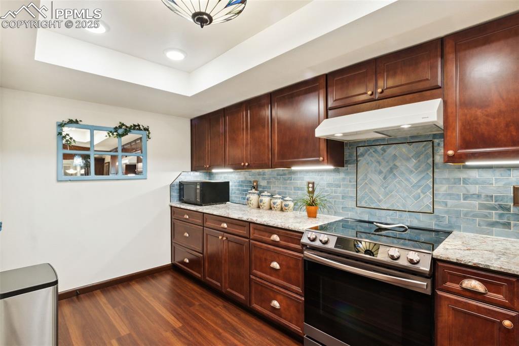 4835 Castledown Road Colorado Springs, CO 80917 - Photo 6 of 29 a kitchen with stainless steel appliances granite countertop a stove a sink and a microwave