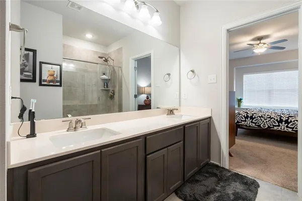 a en suite bathroom with a double vanity sink a mirror and a shower