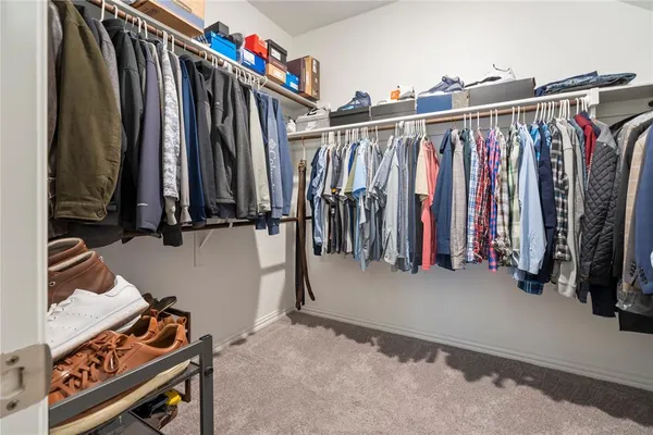 a view of walk in closet with clothes