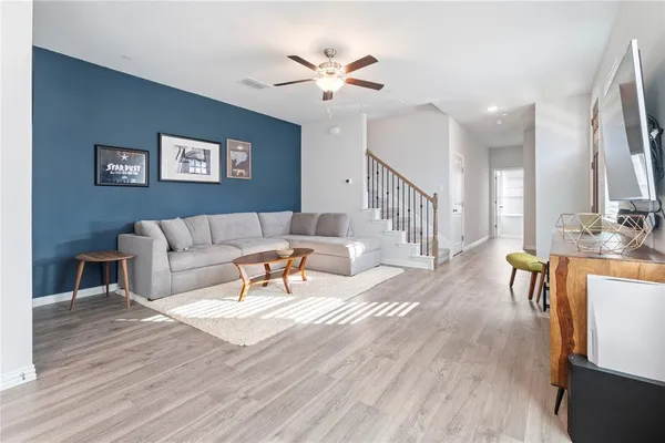 a living room with furniture and a wooden floor