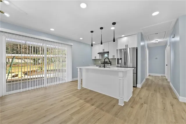 a view of a kitchen with a sink and refrigerator