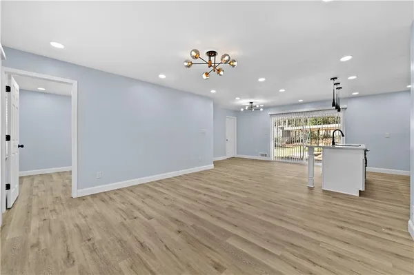 a view of a living room and kitchen with wooden floor