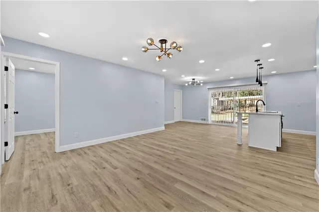 a view of a living room and kitchen with wooden floor