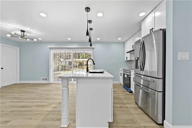 a kitchen with stainless steel appliances granite countertop a refrigerator and a sink