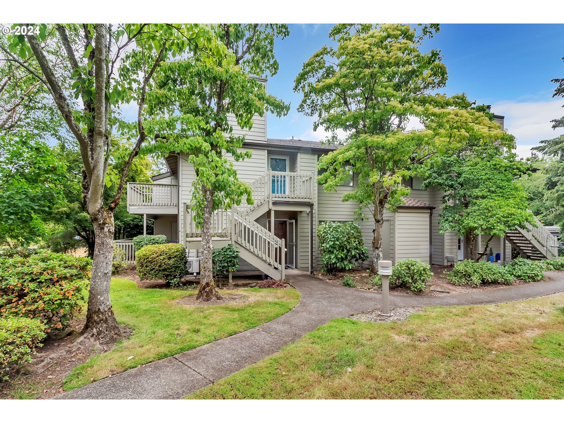 a view of a house with backyard and a tree