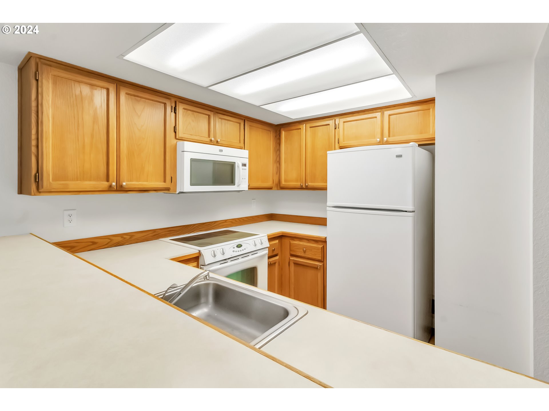 2051 Lake Isle Terrace Eugene, OR 97401 - Photo 16 of 36 a kitchen with a refrigerator a stove top oven and a window