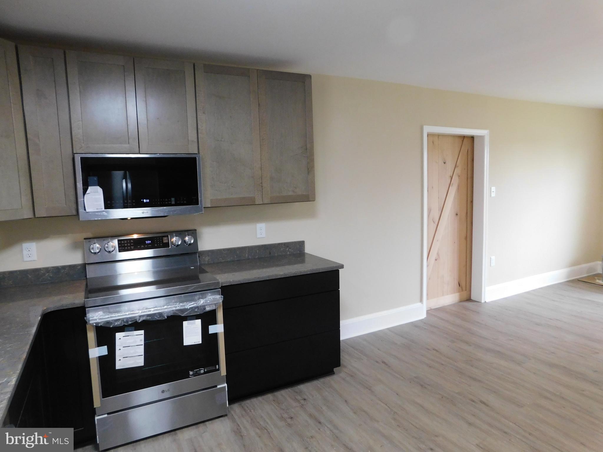 233 Hartly Road Hartly, DE 19953 - Photo 17 of 70 a kitchen with granite countertop a stove and a wooden floor
