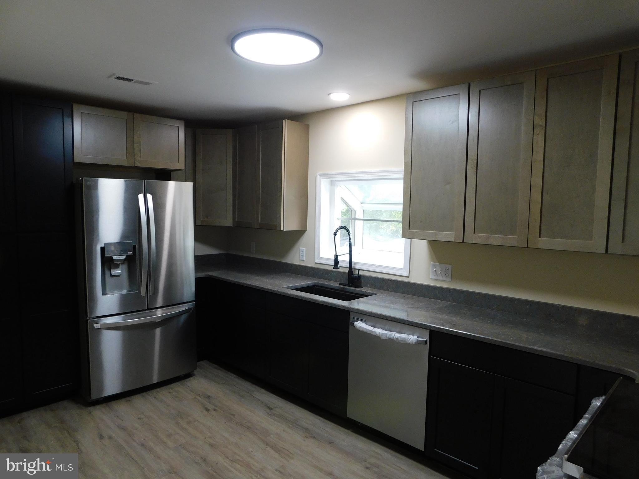 233 Hartly Road Hartly, DE 19953 - Photo 8 of 70 a kitchen with granite countertop stainless steel appliances and wooden cabinets