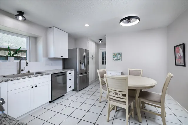 a kitchen with white cabinets and stainless steel appliances